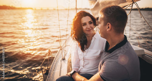 Beautiful couple looking in sunset from the yacht. Romantic vacation .