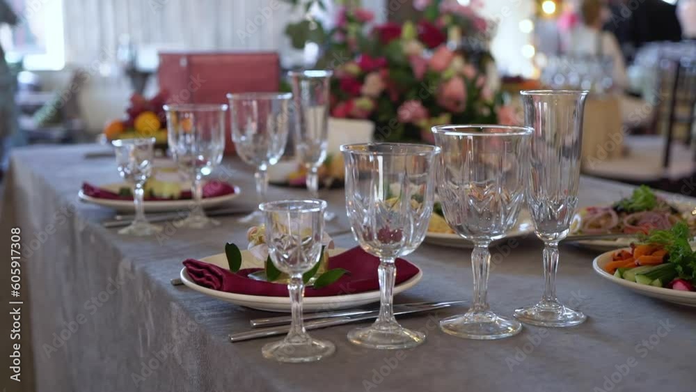 Served tables for a holiday in a restaurant. Glasses, plates, cutlery, napkins. Wedding decor, celebration dinner or party, reception indoors. No food.