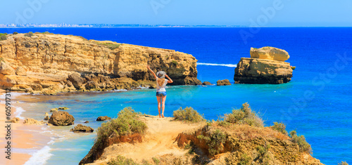 Algarve coast in Portugal- Woman tourist enjoying panoramic view of beautiful beach