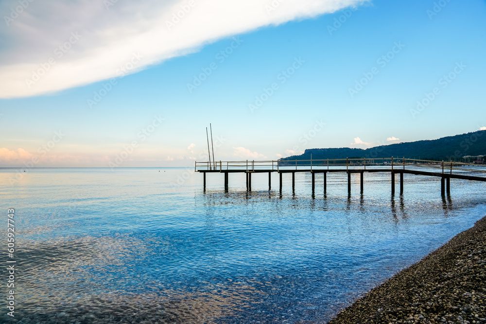 Mediterranean Sea near Kemer. Landscape in Turkey. Nature on the beach with a jetty in the background.
