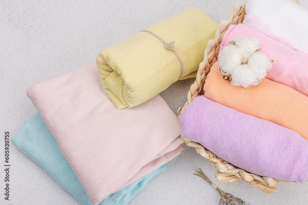 Vertical storage of clothing. Spring closet cleaning, eco friendly basket, pastel baby T-shirts Vertical storage of clothing. Spring closet cleaning, eco friendly basket, pastel baby T-shirts