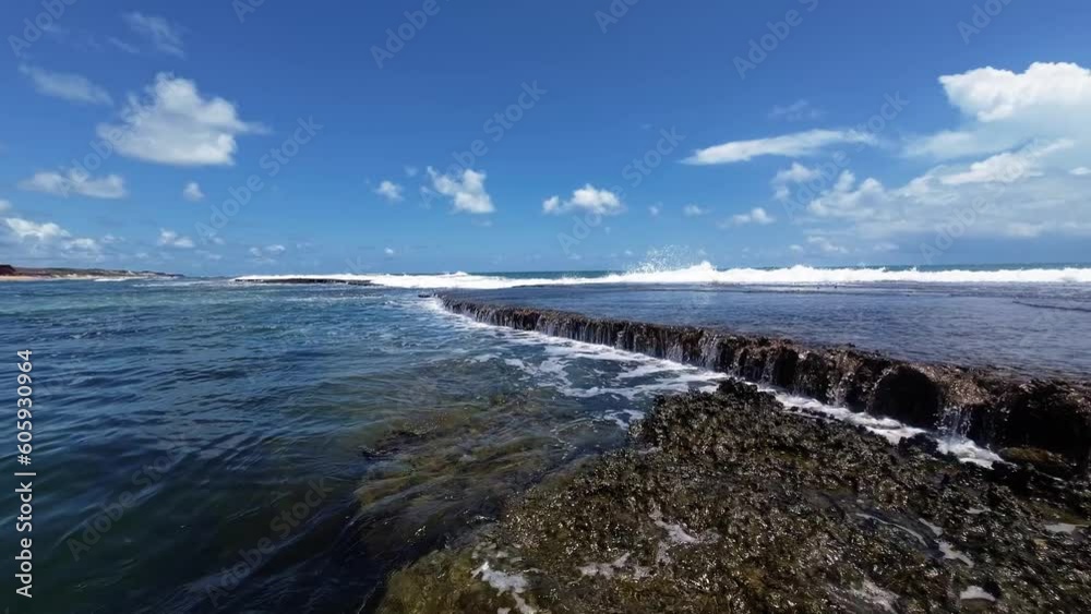 A beautiful natural waterfall on the beach in Sibauma created from a long reef rock creating natural pools for swimming located in Tibau do Sul, Brazil in Rio Grande do Norte near Pipa on a sunny day. A beautiful natural waterfall on the beach in Sibauma created from a long reef rock creating natural pools for swimming located in Tibau do Sul, Brazil in Rio Grande do Norte near Pipa on a sunny day.