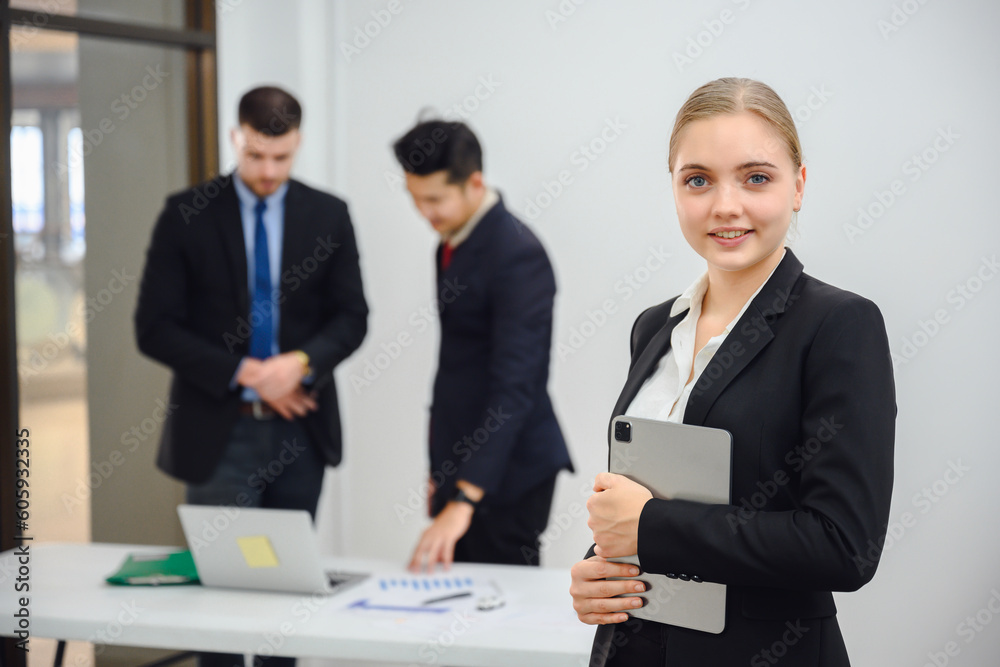 Young happy businesswoman looking into camera holding tablet Confident smiling business boss standing in office at team meeting Portrait of confident business woman with colleague in conference room Young happy businesswoman looking into camera holding tablet Confident smiling business boss standing in office at team meeting Portrait of confident business woman with colleague in conference room