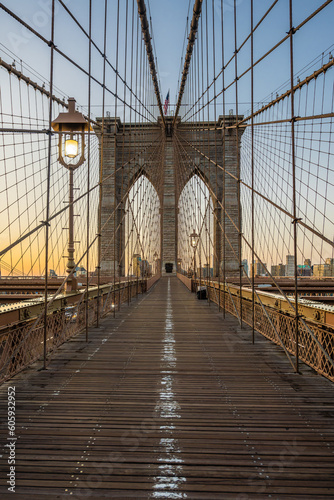 The Brooklyn bridge and lighting lamps early in the morning dawn.