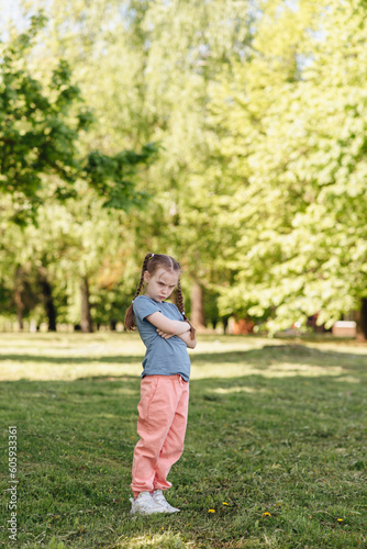 a girl with pigtails in a green summer park looking 