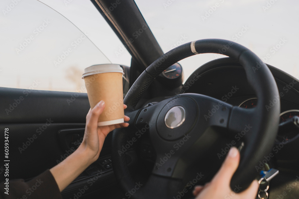 careless driving, female driver holding a cup of coffee while driving a car