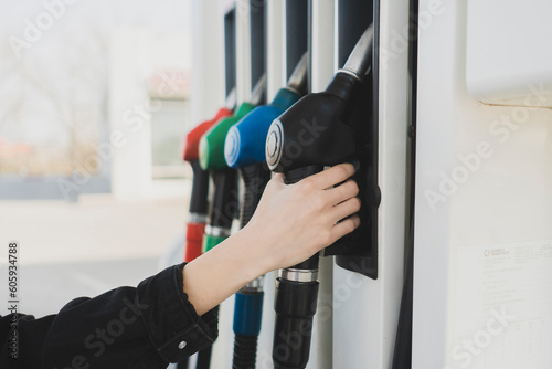 person holding a fuel pump on the gas station