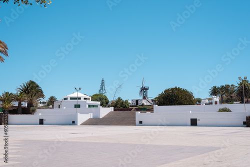 Typical Canary Islands street with white houses, green wooden doors and windows and colorful flowers in Teguise village, Canary Islands, Spain.