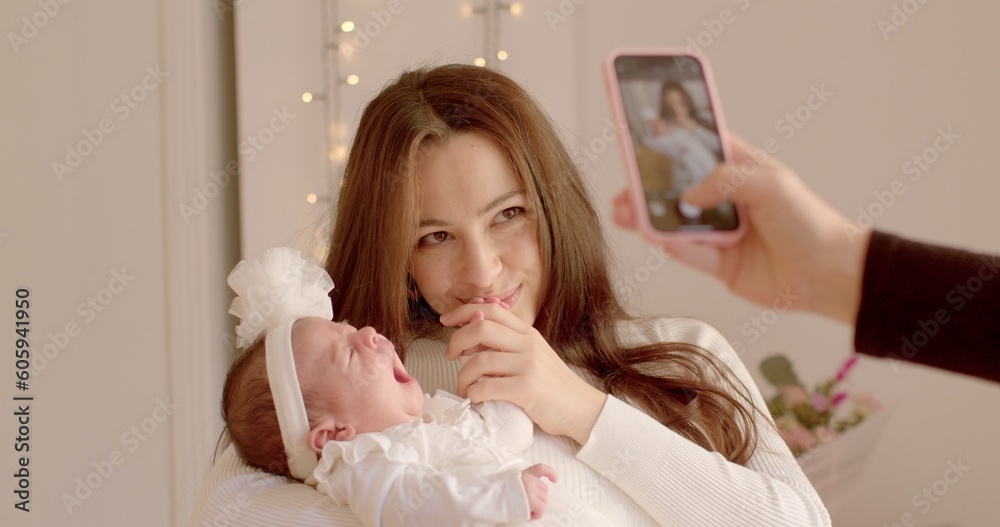 Using the LTE network for data transmission. Young mother with cute newborn baby taking pictures with phone. Creation of content for social networks. Using the LTE network for data transmission. Young mother with cute newborn baby taking pictures with phone. Creation of content for social networks.