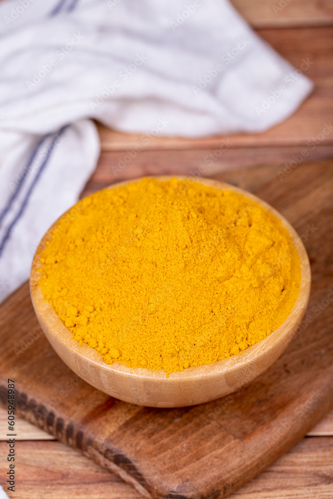 Powdered turmeric on wooden background. Dried ground turmeric powder spices in wooden bowl. Close up Powdered turmeric on wooden background. Dried ground turmeric powder spices in wooden bowl. Close up