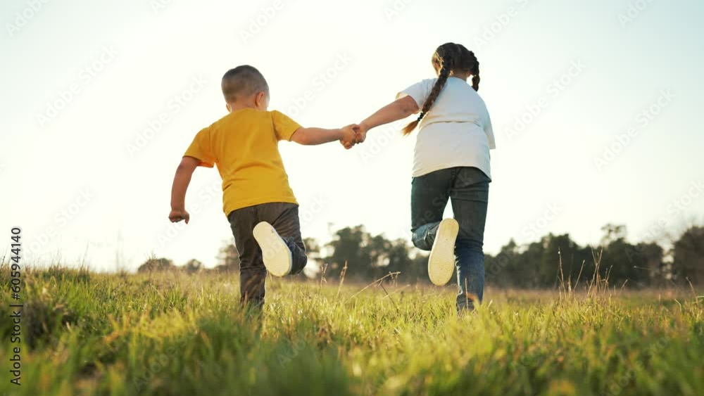 Happy children. boy and girl run across green field in park. Cheerful child is playing on green grass.Summer freedom kids vacation on green grass.children play in park in nature.Summer vacation family Happy children. boy and girl run across green field in park. Cheerful child is playing on green grass.Summer freedom kids vacation on green grass.children play in park in nature.Summer vacation family