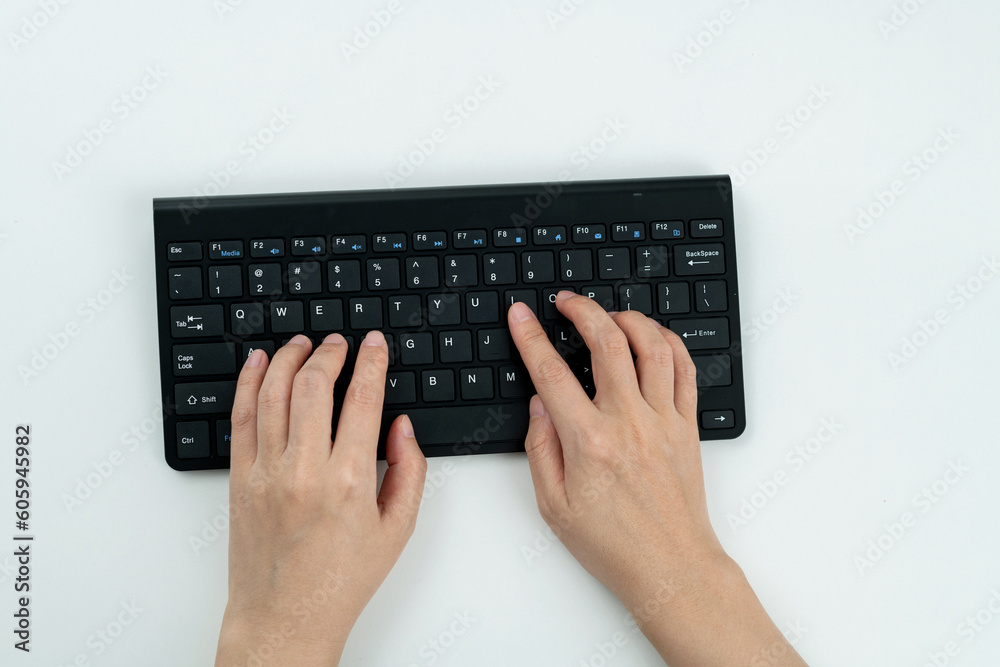 Woman hand tying on wireless keyboard Woman hand tying on wireless keyboard