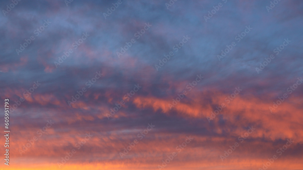 Majestic real sunset sky background with gentle colorful clouds