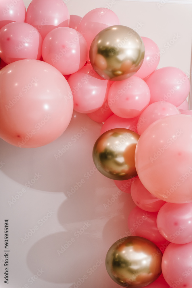 Details. Children's photo wall decoration space, place for text on white background. Birthday party for 1 year old girl on photo zone. Arch decorated with pink, golden balloons. Celebration concept.