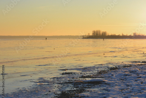 Glowing winter golden sunset reflects off the surface of the ice sea