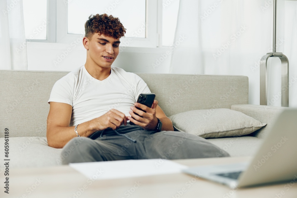 man interior couch smartphone teenager communication mobile laptop male sports adult man interior couch smartphone teenager communication mobile laptop male sports adult