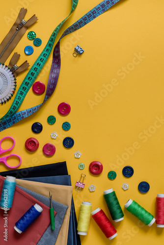Set of bright sewing accessories on a yellow background. Copy space. photo