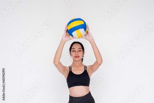 A sporty and athletic young woman passing and holding up the volley ball with both hands. Isolated on a white background.