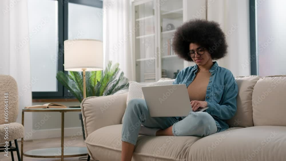 Young African American girl working distant from home with laptop at sofa ethnic woman freelancer typing email on computer online job using web service for e-learning study on couch user browsing net Young African American girl working distant from home with laptop at sofa ethnic woman freelancer typing email on computer online job using web service for e-learning study on couch user browsing net