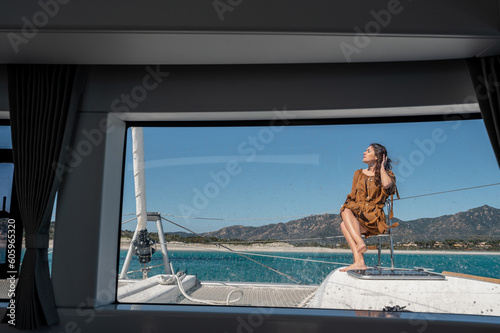 Woman sitting on deck of yacht © Pintau Studio