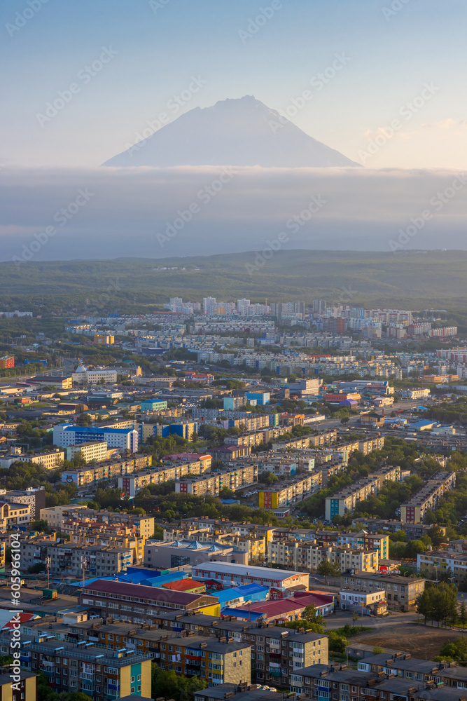 Morning cityscape. Top view of the buildings and streets of the city. Residential urban areas at sunrise. Koryaksky volcano in the distance. Petropavlovsk-Kamchatsky, Kamchatka Krai, Russian Far East.