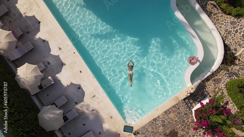 Top view of woman swimming in hotel pool, summer time, drone footage, Turkey