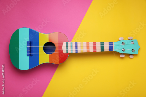 Bright ukulele on color background, top view. String musical instrument