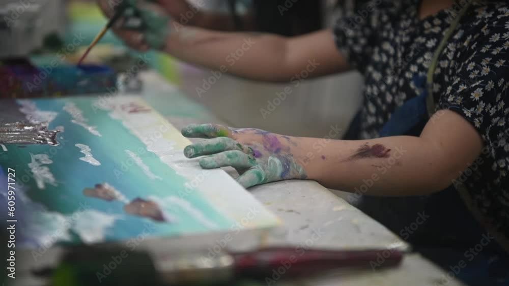 A little girl is painting the picture by using the acrylic color in the painting studio. A little girl is painting the picture by using the acrylic color in the painting studio.