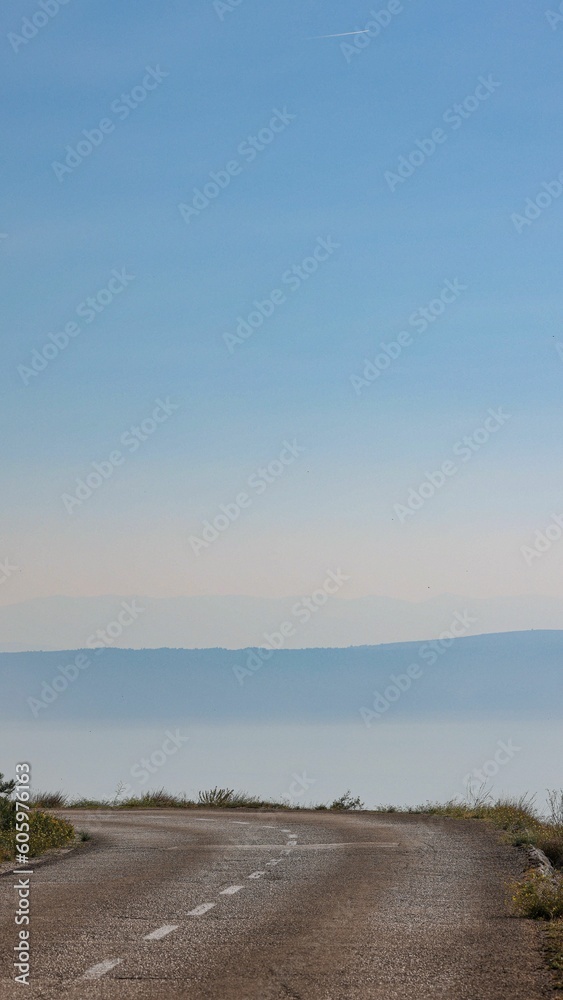Fototapeta premium Vertical shot of a road with a sea in the background in Dalmatia, Croatia