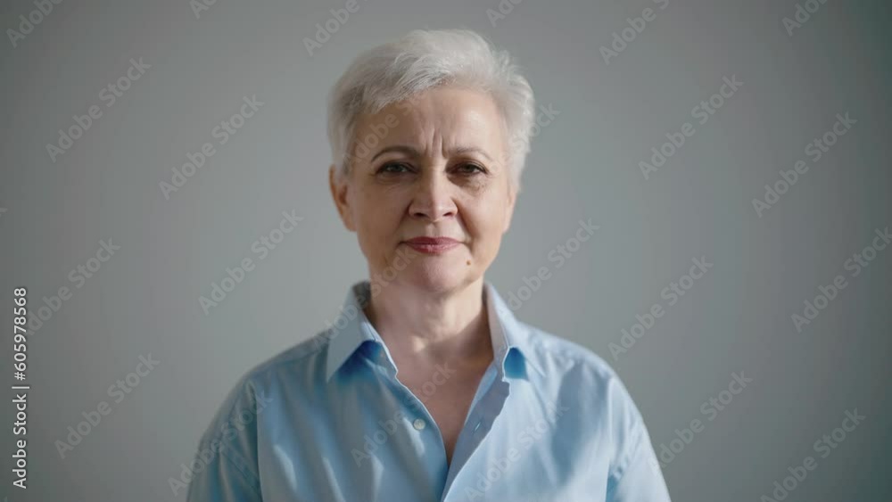 Portrait of happy laughing grey haired senior businesswoman looking at camera on gray background. Professional confident specialist, working elegant stylish woman successful career in old age concept.