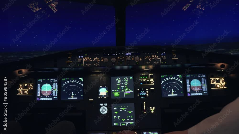 Pilots flying a plane with illuminated buttons for a flight simulator at night