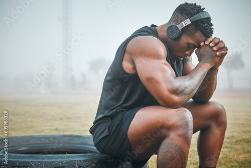 Music, fitness and thinking with black man in park for exercise, strong and motivation. Streaming, sports podcast and radio with male athlete training in nature for muscle, workout and challenge