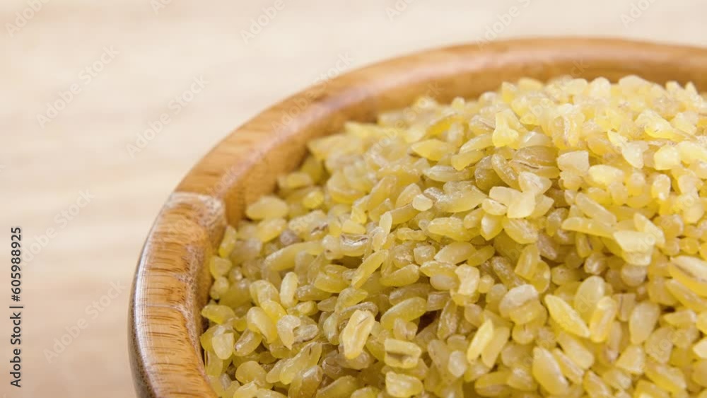 Close-up of a bunch of bulgur spinning in the bowl on the blurred background Close-up of a bunch of bulgur spinning in the bowl on the blurred background