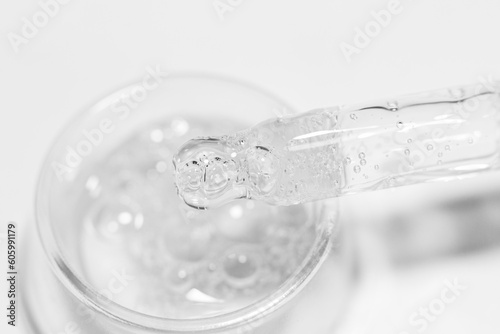 Transparent gel or liquid with bubbles in a round container. Pipette