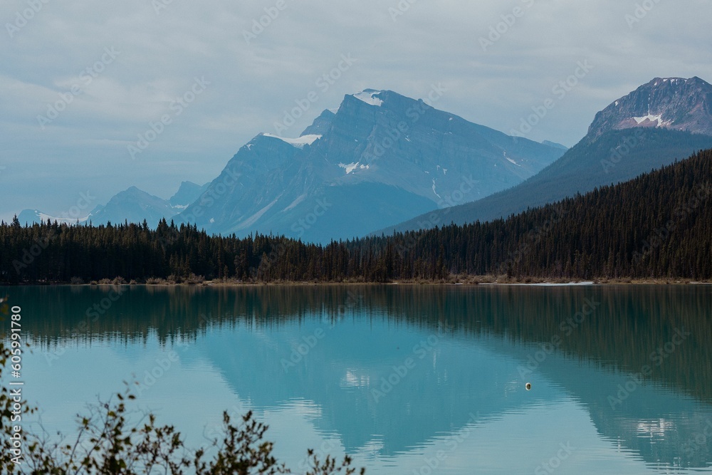 Beautiful view of a blue lake in a mountainous landscape under a cloudy sky Beautiful view of a blue lake in a mountainous landscape under a cloudy sky