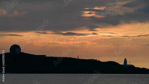 At dusk, the sun goes towards the horizon, the silhouette of the lighthouse. Fugui Cape Lighthouse is known for its sunset shots and tourist attractions. photo