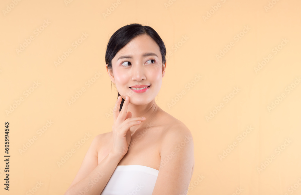 Beautiful girl asian model touching fresh glowing hydrated facial skin on beige background closeup. Beauty face young woman with natural makeup and healthy skin portrait. Skin care concept Beautiful girl asian model touching fresh glowing hydrated facial skin on beige background closeup. Beauty face young woman with natural makeup and healthy skin portrait. Skin care concept