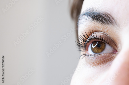 Close-up of a woman's eye after an eyelash lamination procedure. 
