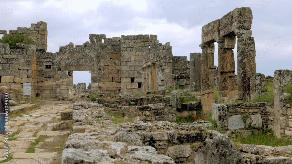 Pan shot to female tourist visiting unesco ancient Turkish city hierapolis Pan shot to female tourist visiting unesco ancient Turkish city hierapolis