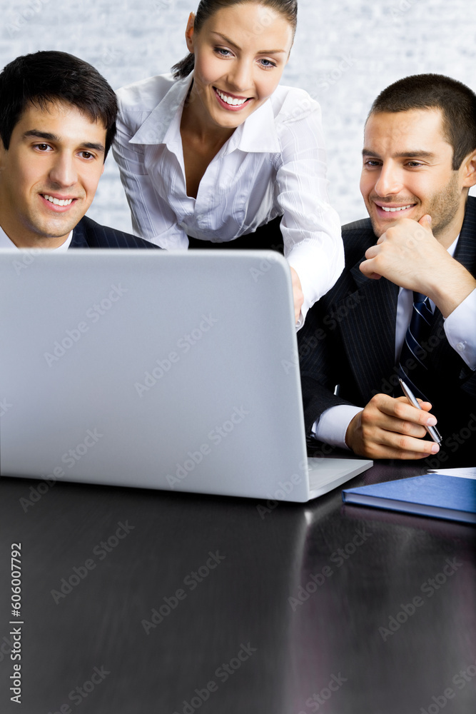 Portrait photo - confident business people employees watch laptop at office workplace. Partners, colleagues, co-workers working together. Businesswoman and businessmen on white bricks wall background. Portrait photo - confident business people employees watch laptop at office workplace. Partners, colleagues, co-workers working together. Businesswoman and businessmen on white bricks wall background.