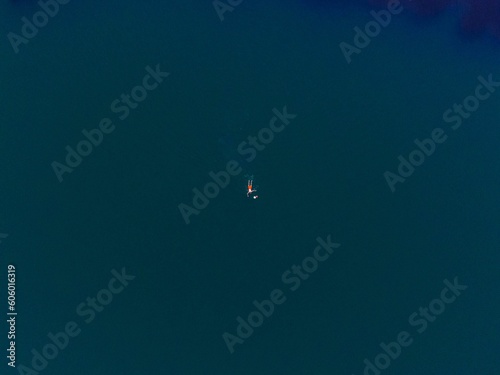 Aerial top view shot of a man swimming in a sea in summer