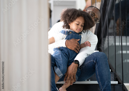 Quadro em tela Adorable multiracial little kid walk down the stairs with her father and sitting on alphabet stairway at home
