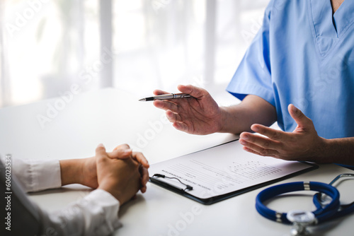 Doctor talking to patient and filling patient history, examination, treatment, medical and health concept.