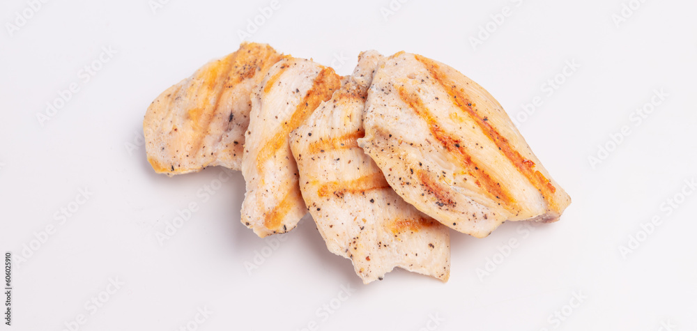 Grilled pieces of chicken breast on a white background. Grilled food with shadows, grilling season Grilled pieces of chicken breast on a white background. Grilled food with shadows, grilling season