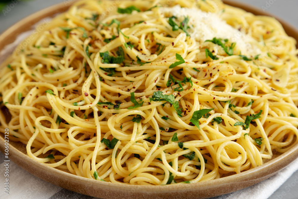 Homemade Italian Spaghetti Aglio e Olio on a Plate, side view. Close-up. Homemade Italian Spaghetti Aglio e Olio on a Plate, side view. Close-up.