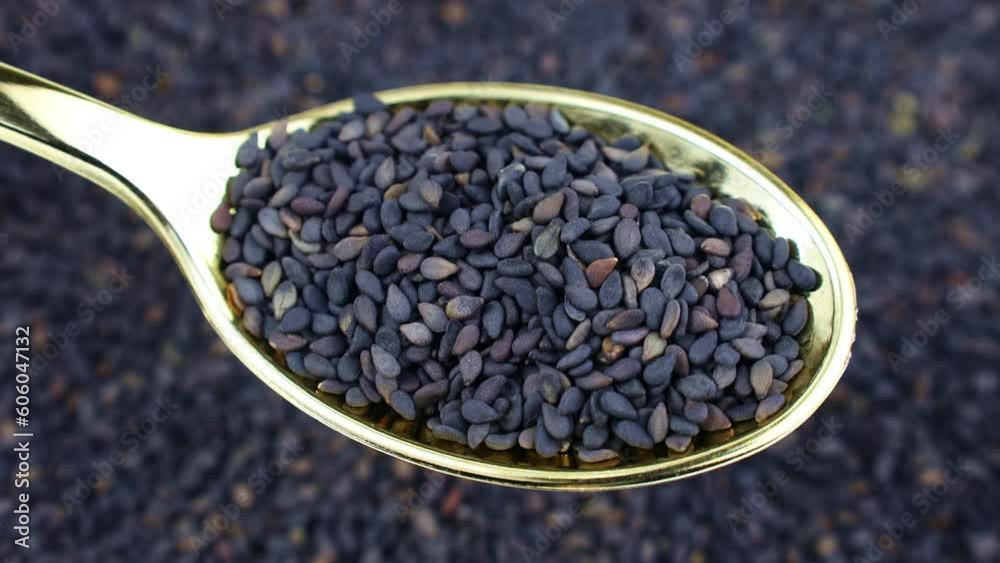 Black sesame seeds in the spoon with circle rotation close up Black sesame seeds in the spoon with circle rotation close up