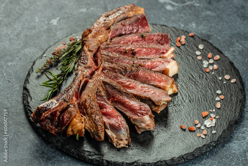Grilled ribeye beef steak with red wine, herbs and spices. Marbled beef steak medium rare on a black background with copy space
