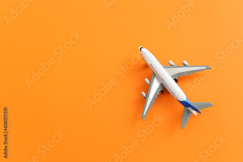 Top view of orange background and airplane. Concept of travel, vacation