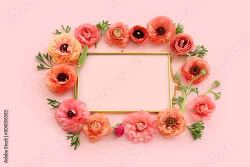 top view of pink flowers and gold elegant empty frame over pastel background. For mock up, copy space