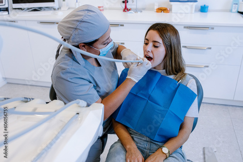 Dentist treating teeth of patient in clinic photo